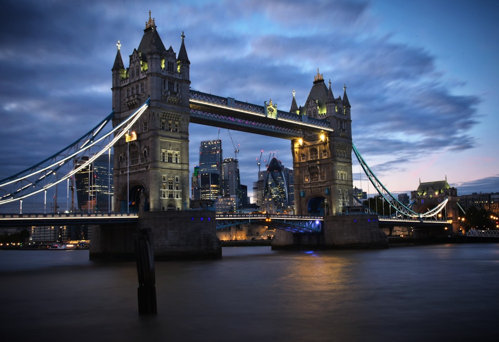 the tower bridge is lit up at night