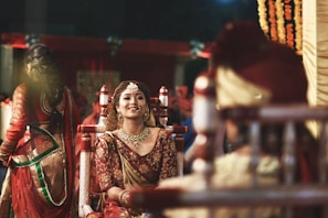 A smiling bride in traditional attire holding hands with her family, radiating happiness on her wedding day supported by Swagathii Vivah Sahayata Foundation.