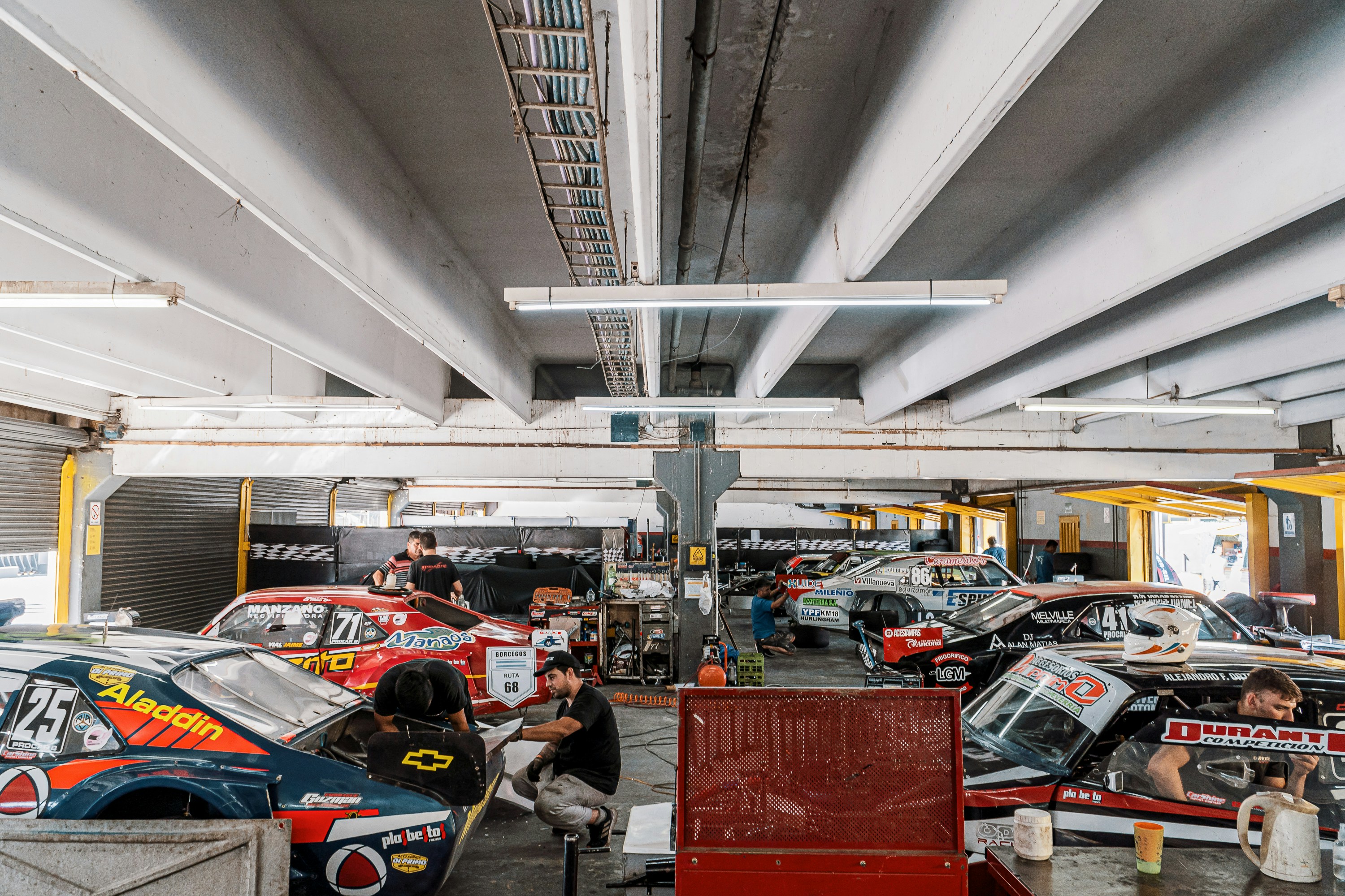 A group of cars parked inside of a garage photo Free Autódromo oscar
