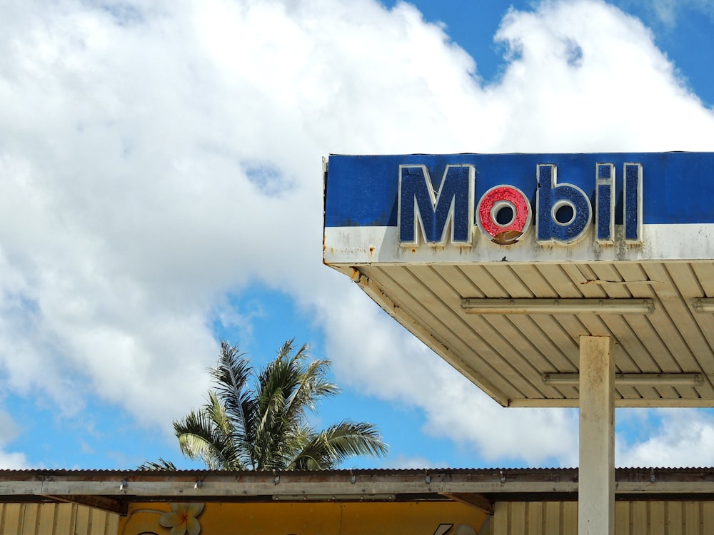 a blue and white sign for a motel on a cloudy day