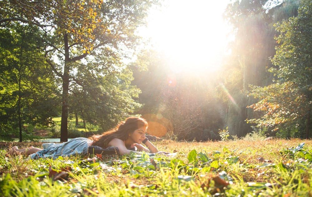 a woman laying on the ground in the grass