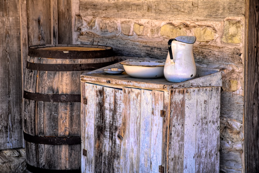 a white vase sitting on top of a wooden table