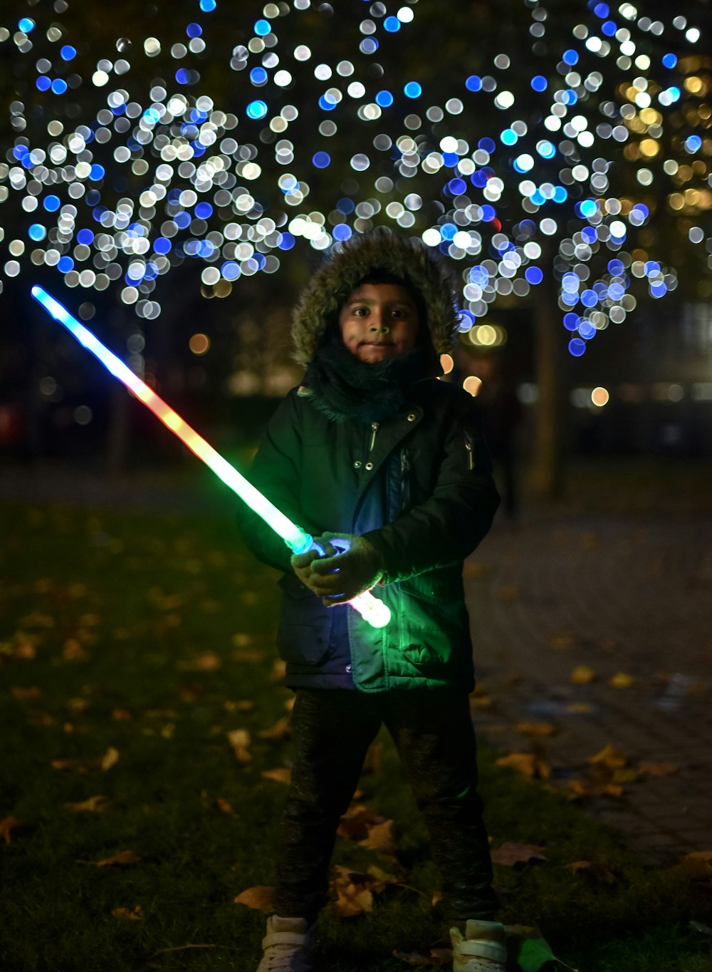 a person holding a light saber in a park