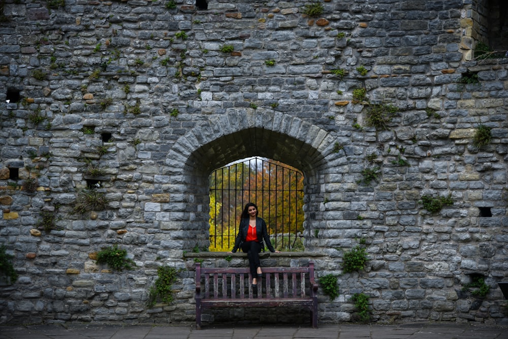 a woman sitting on a bench in front of a window