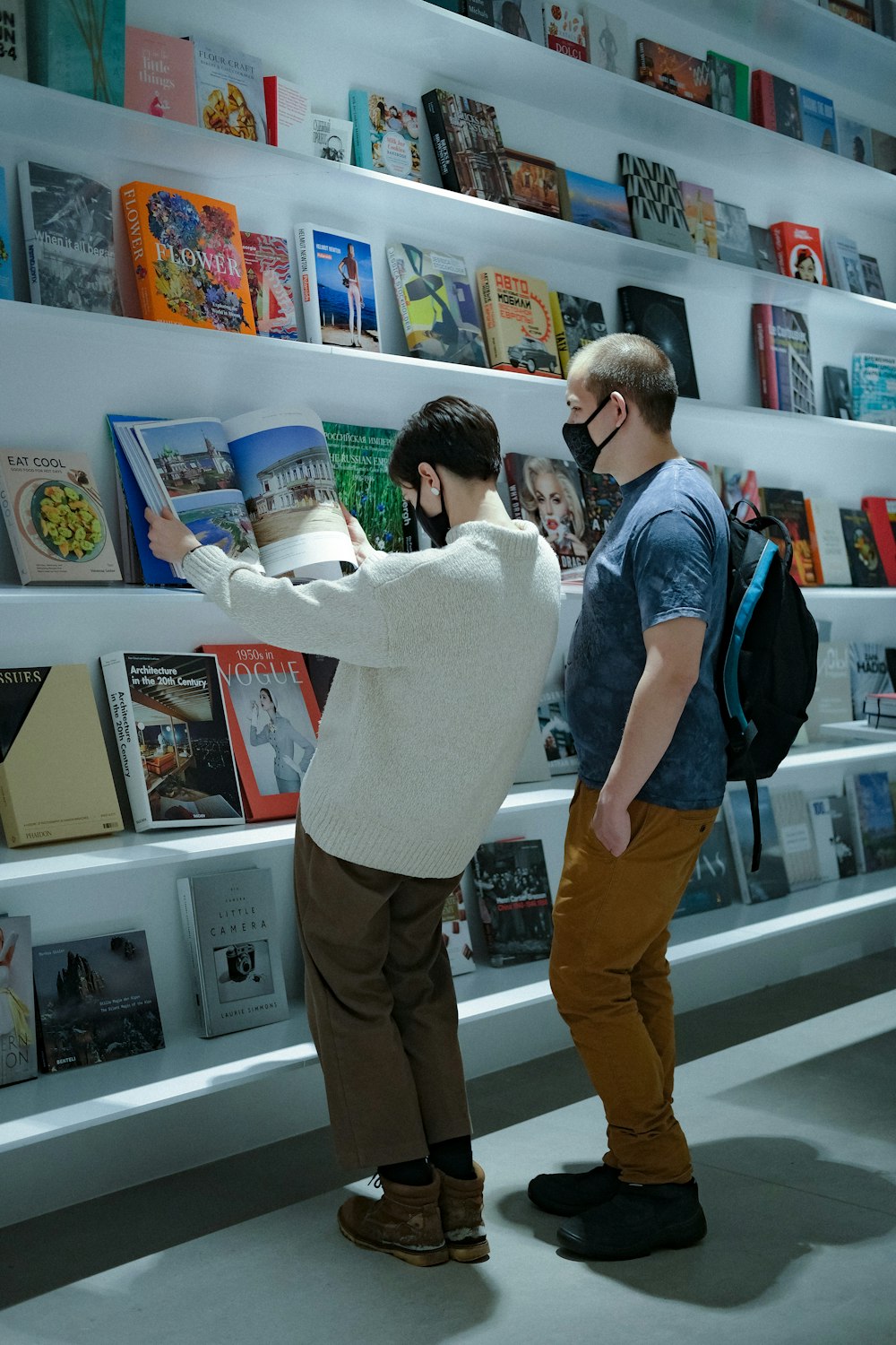 a couple of people standing in front of a book shelf