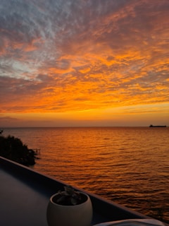 A vibrant sunset over a luxury cruise ship sailing through calm blue waters