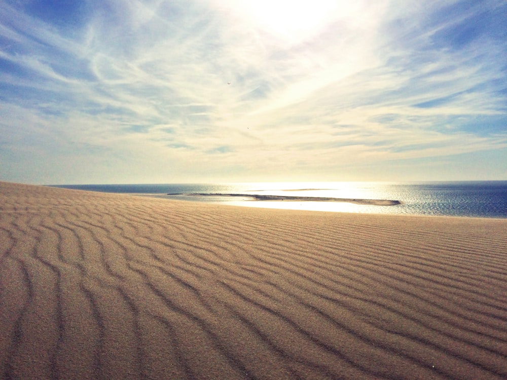 the sun is shining over a sandy beach