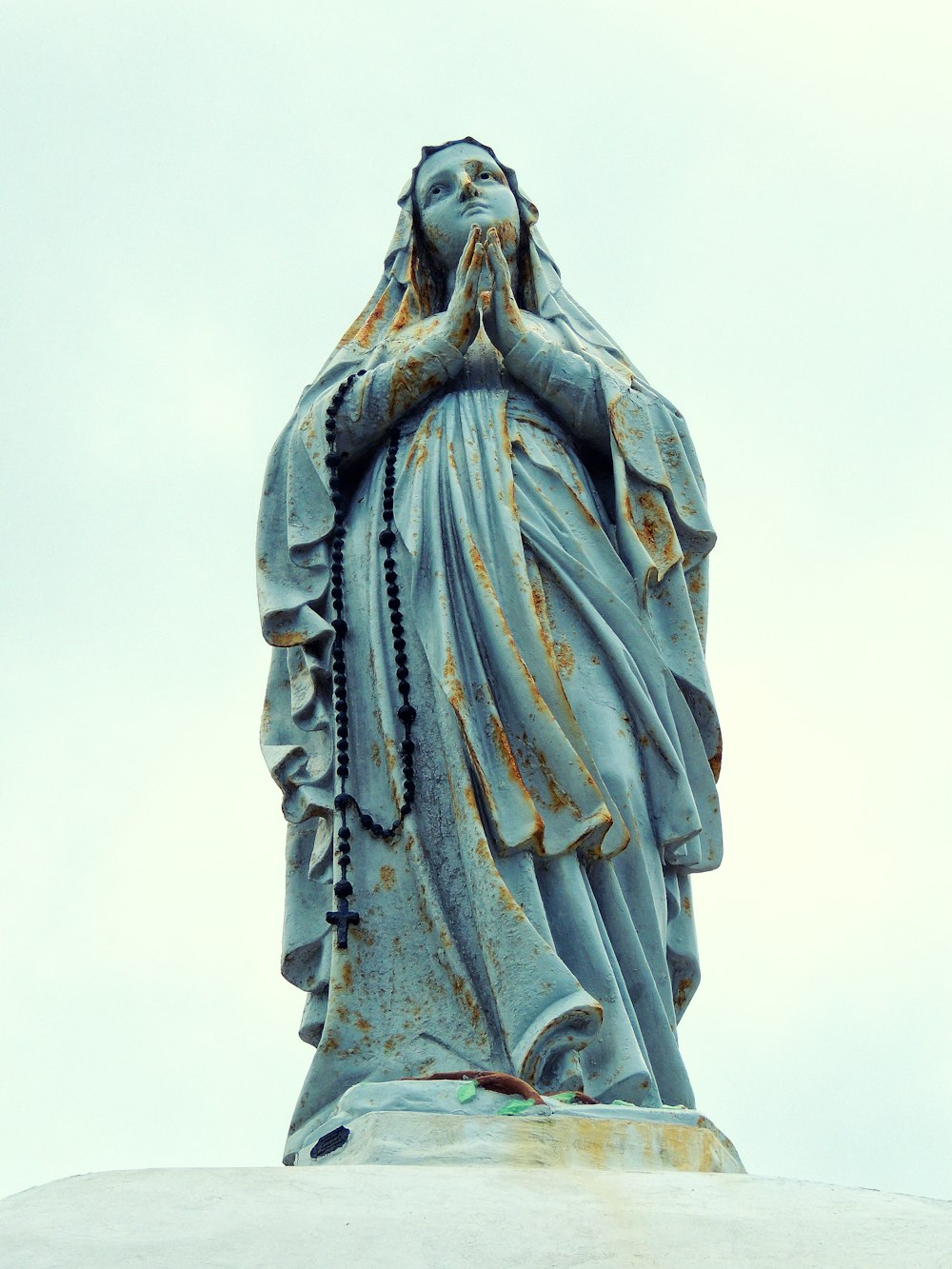 una statua di una donna che si porta le mani al viso