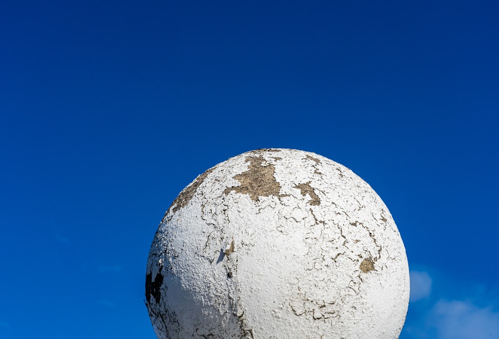 a large white ball sitting in the middle of a blue sky