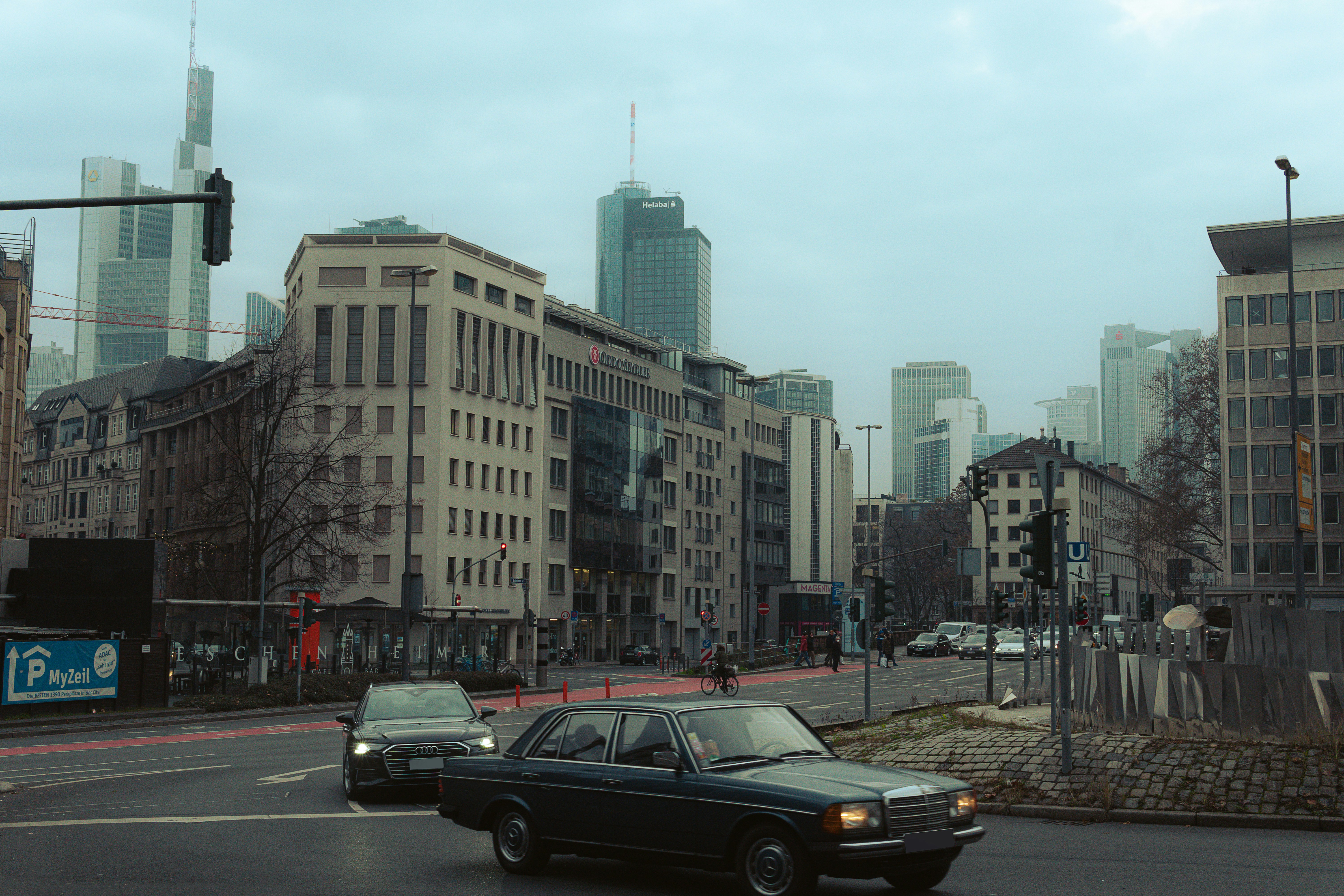 a black car driving down a street next to tall buildings