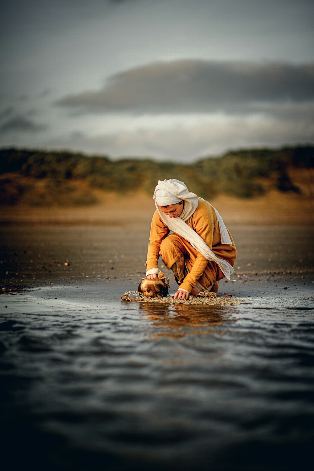 a person kneeling down in the water with a frisbee