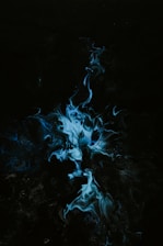 a black background with blue smoke coming out of it