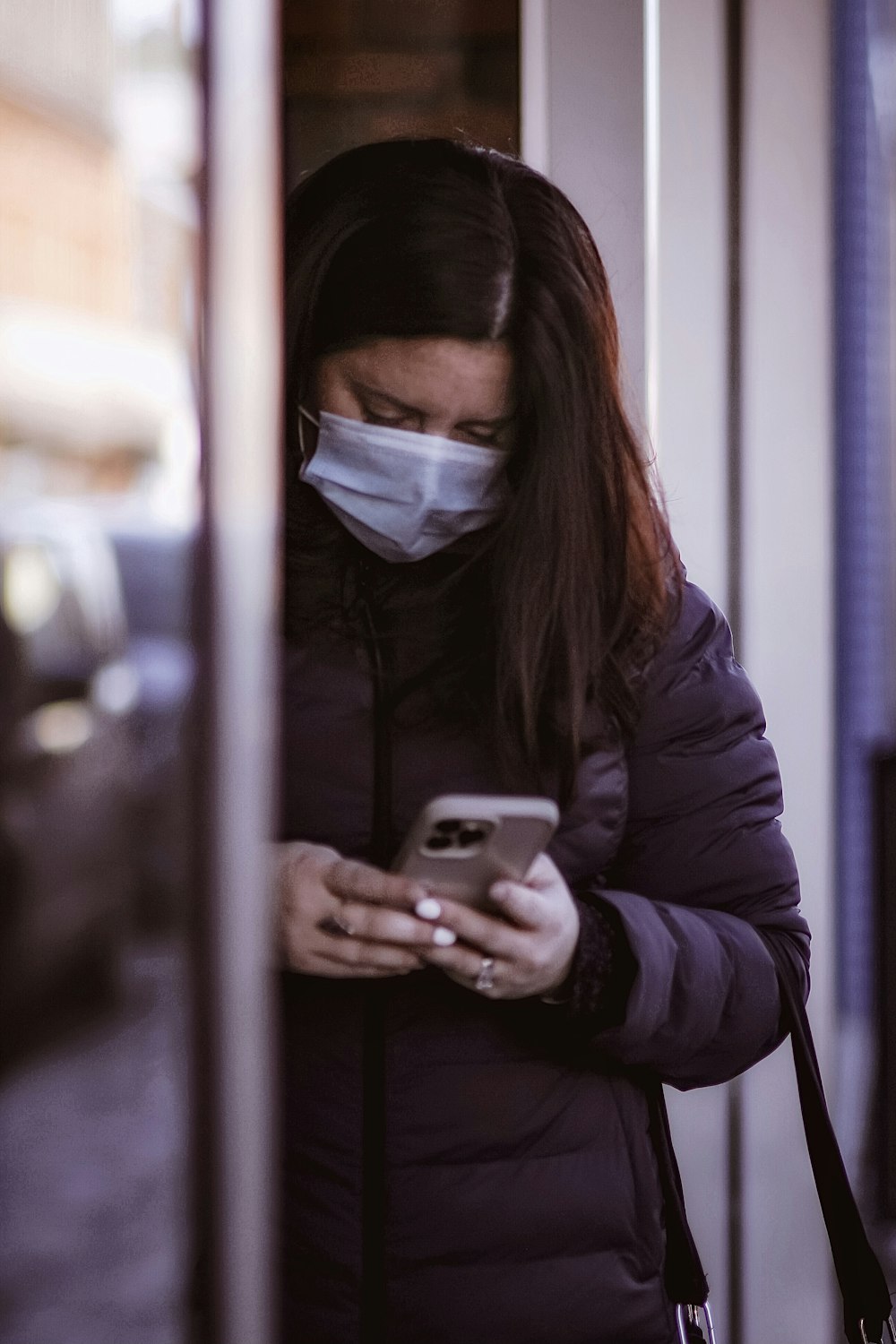 a woman wearing a face mask looking at her cell phone