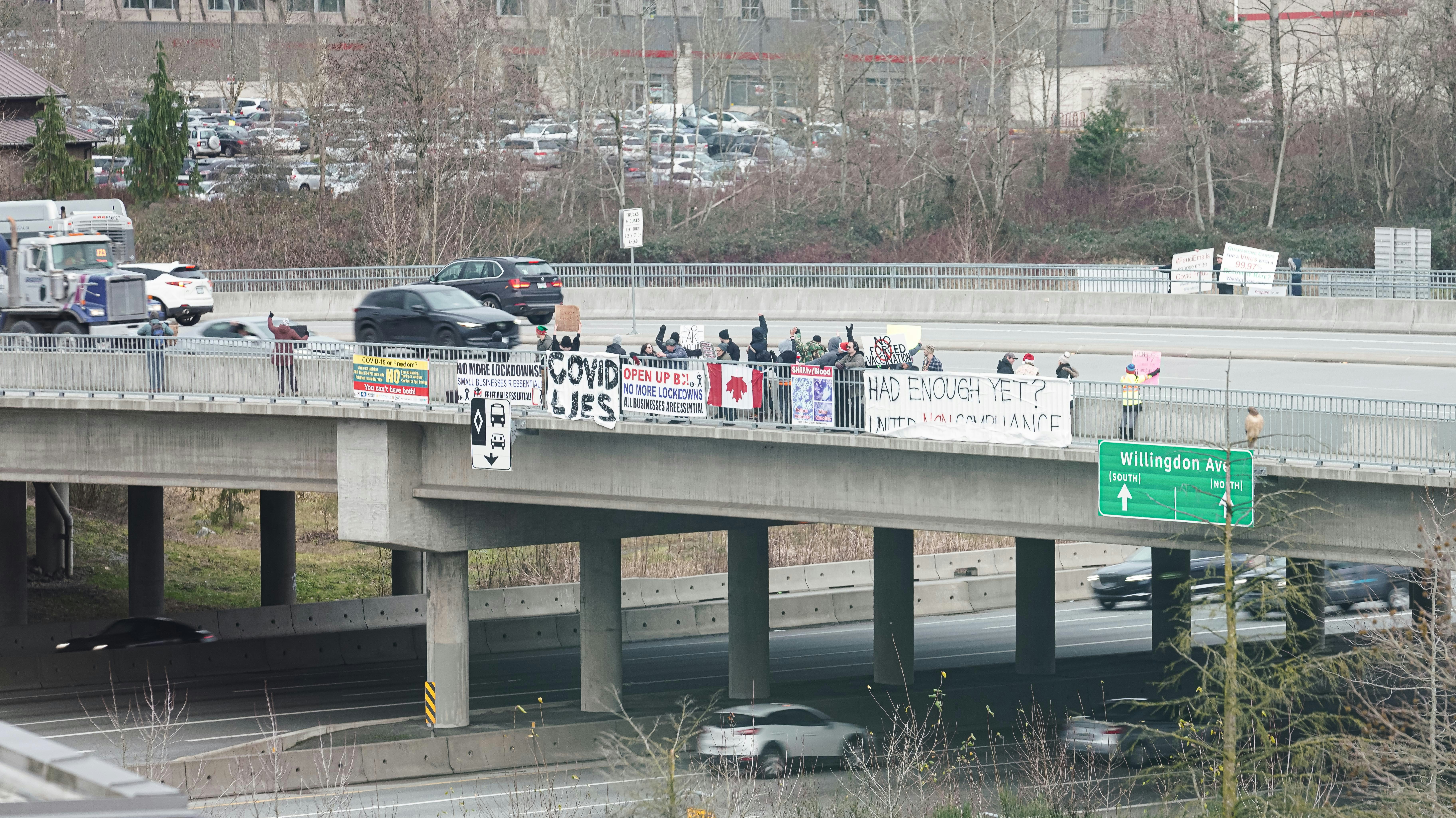 a group of people standing on the side of a bridge