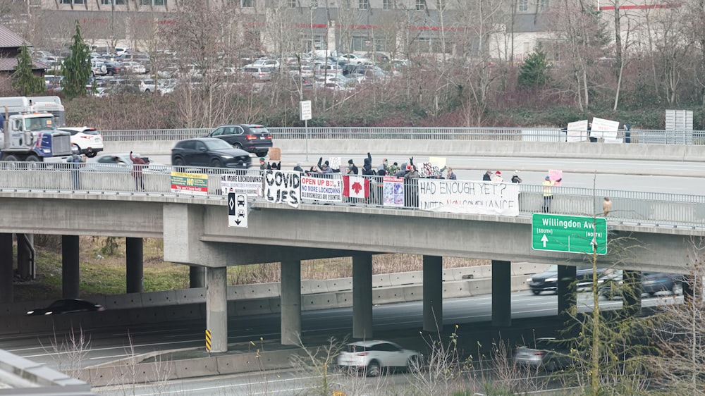 a group of people standing on the side of a bridge