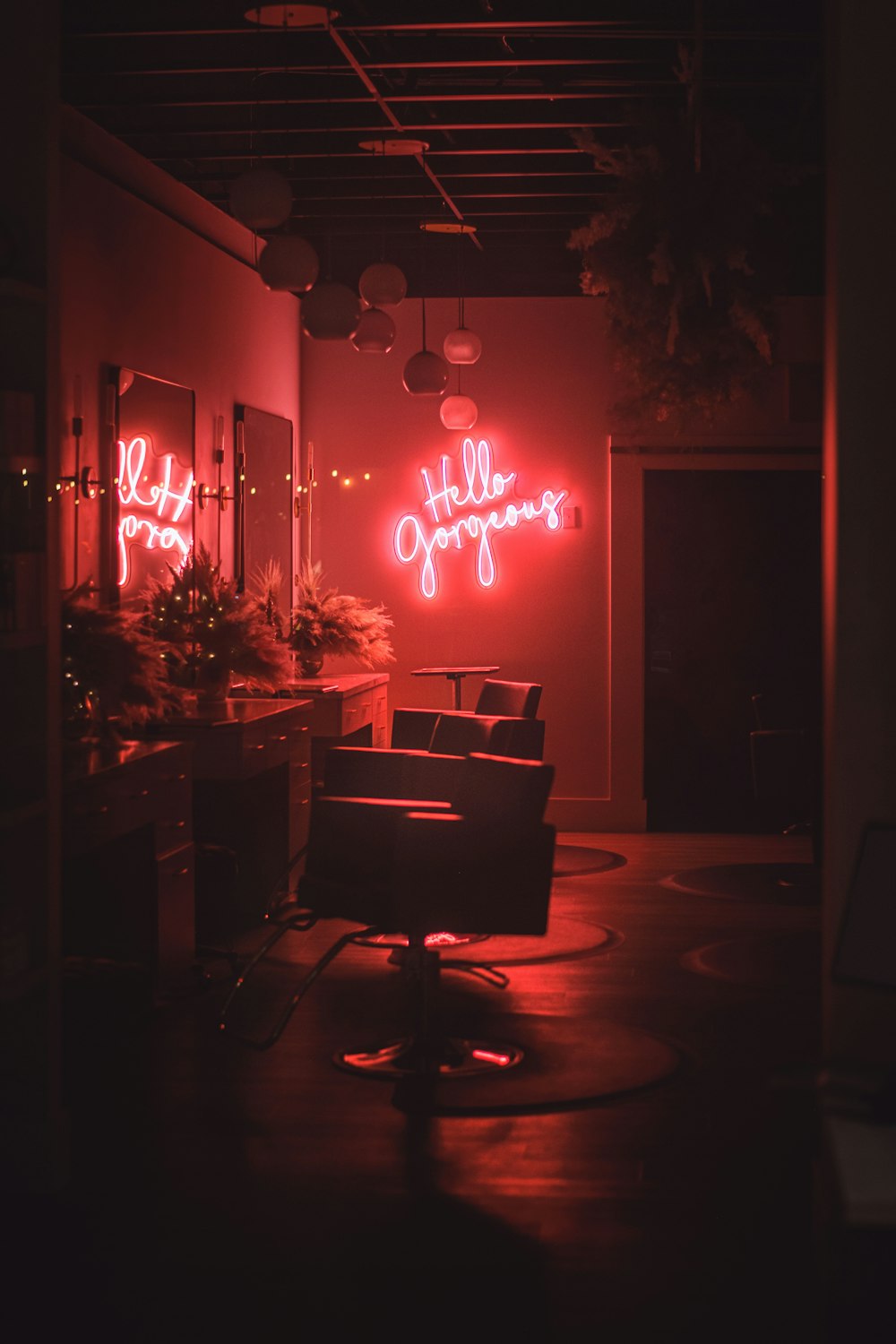a room with a chair and a neon sign on the wall