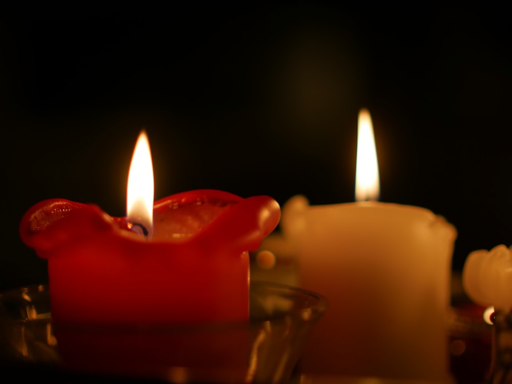 a close up of a candle with two candles in the background