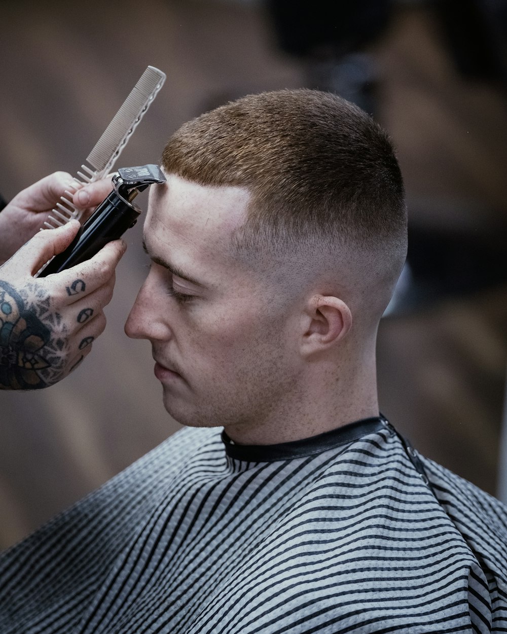 a man getting his hair cut by a barber