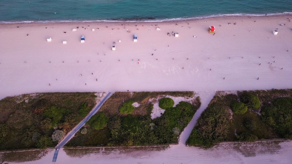 an aerial view of a beach with people and boats