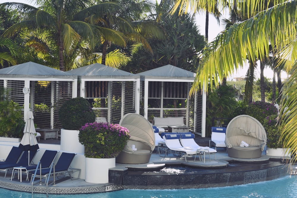 a pool with lounge chairs and umbrellas next to it