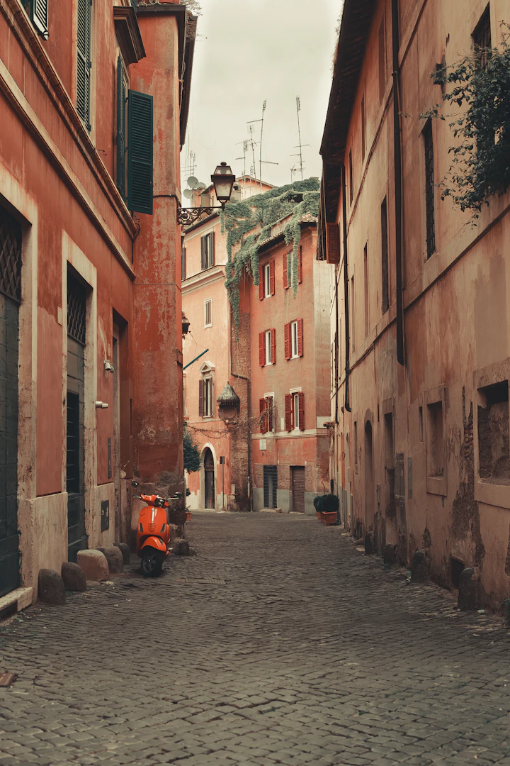 Rua de paralelepípedos entre fachadas antigas em Roma