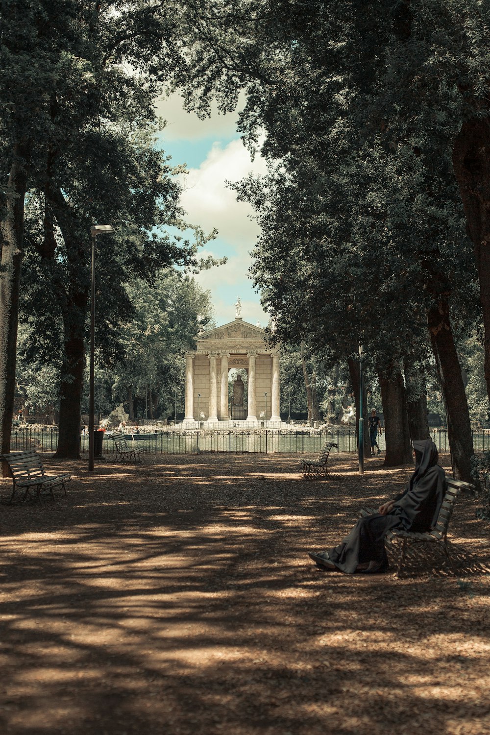 a person sitting on a bench in a park