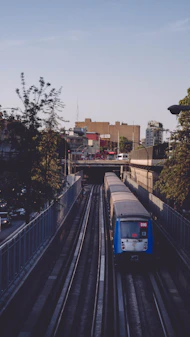 a train traveling down train tracks next to a tall building