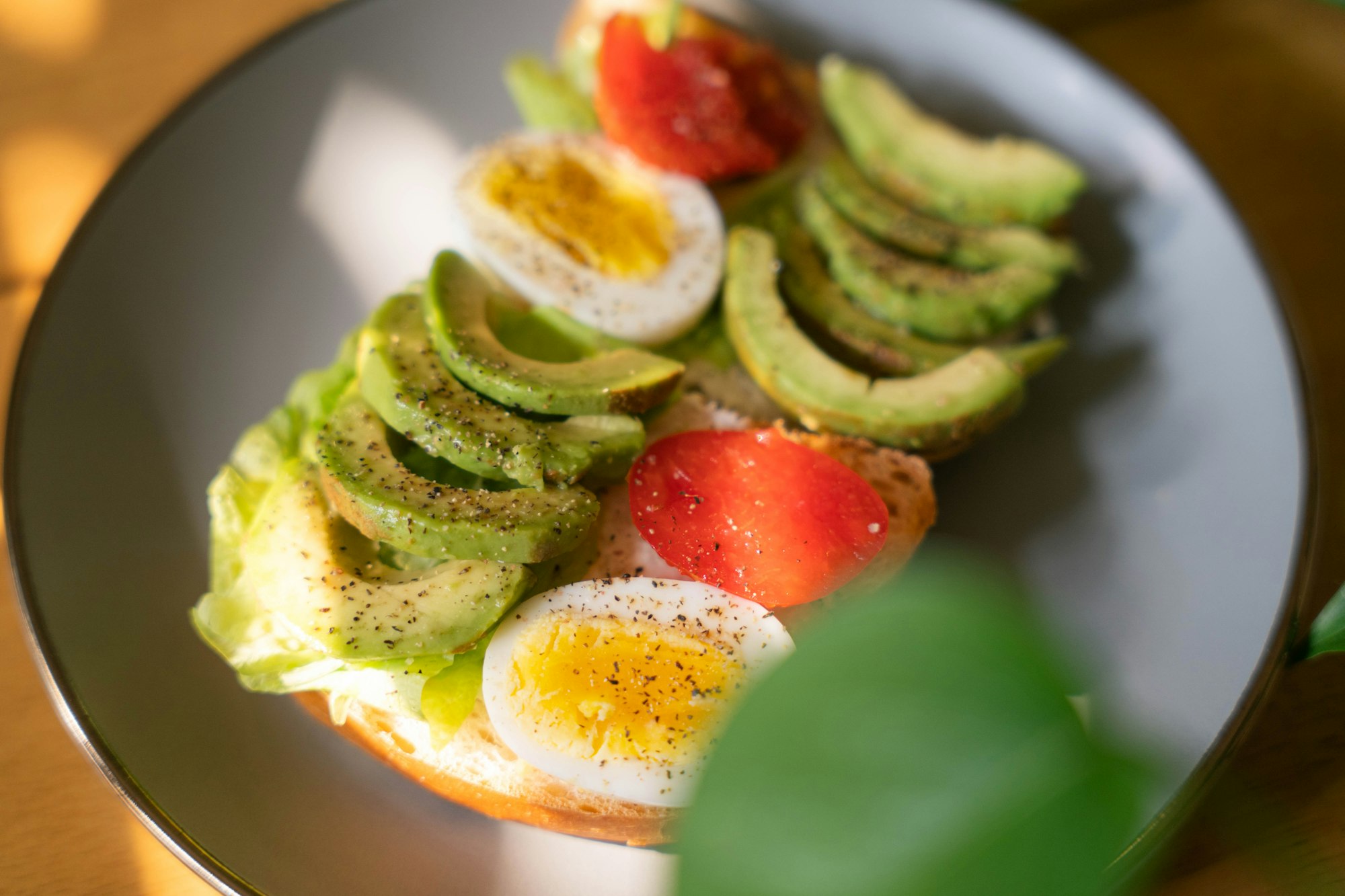 a plate of food with avocado, tomato, and hard boiled eggs