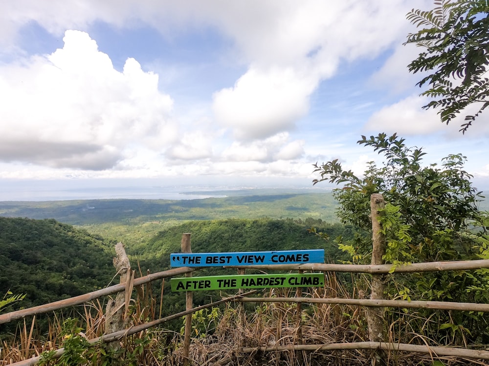 a blue sign that is on a wooden fence