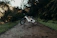 Close-up of a sleek electric dirt bike with custom suspension and brake upgrades on a forest trail.