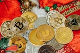 a pile of gold and silver coins sitting on top of a red blanket