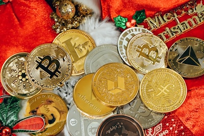 a pile of gold and silver coins sitting on top of a red blanket