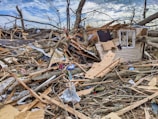 a pile of debris with a house in the background