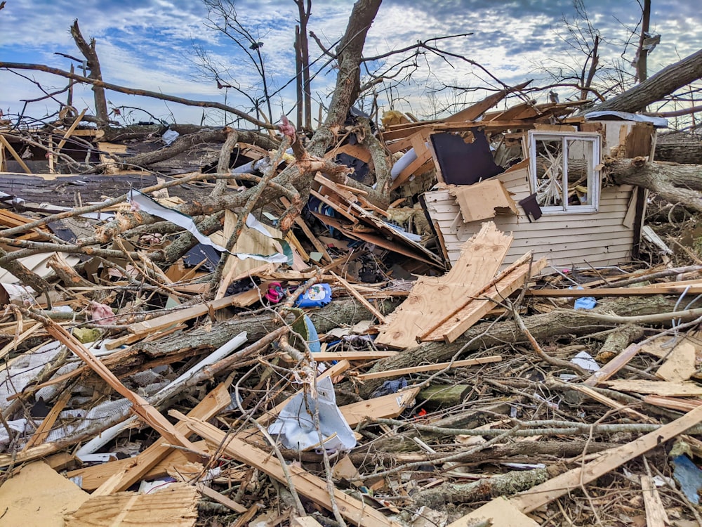 a pile of debris with a house in the background