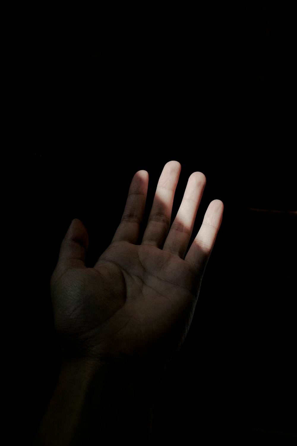 a person holding their hand up in the dark