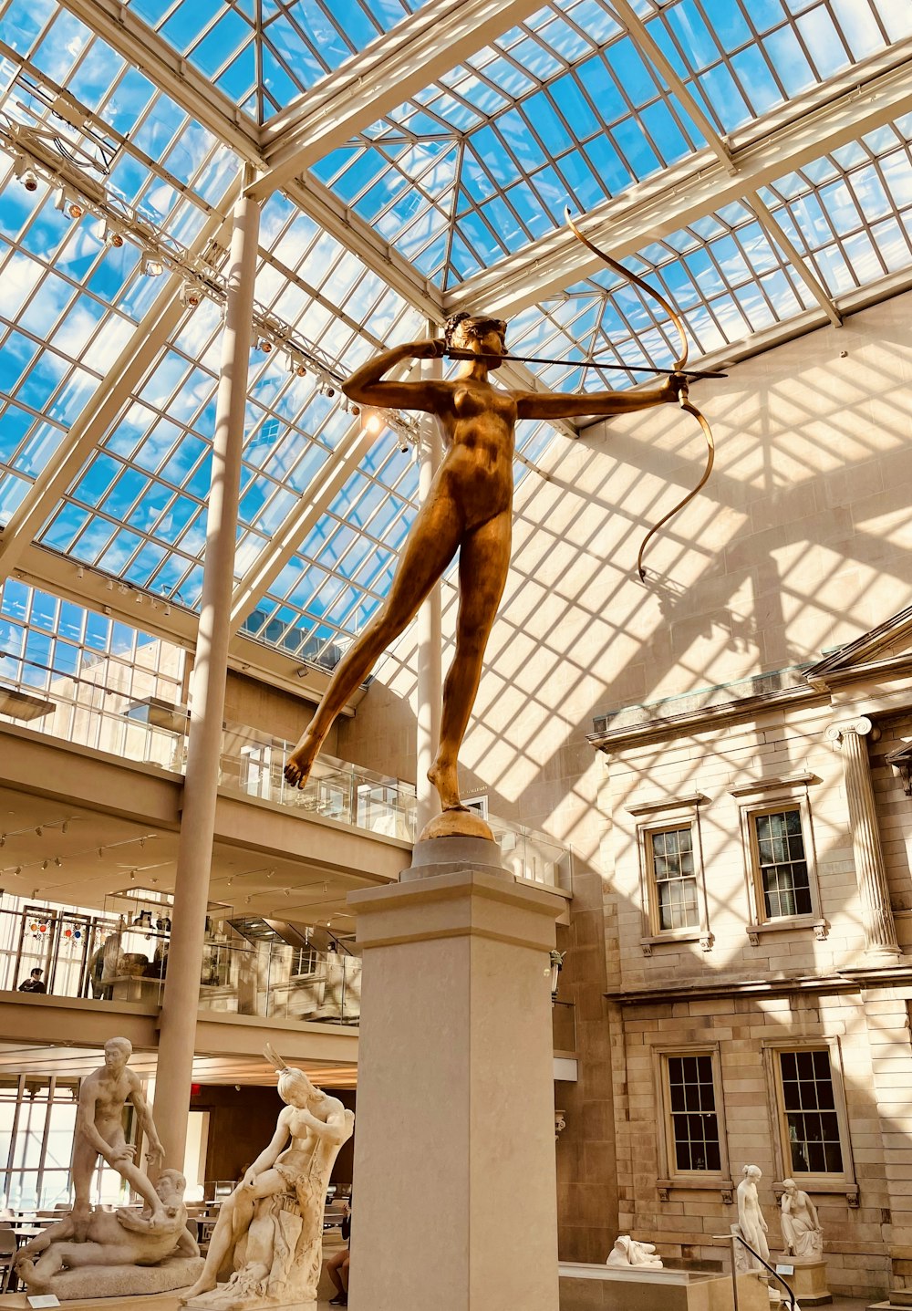 a statue of a woman holding a bow in a building