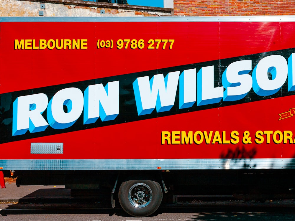 a red box truck parked in front of a brick building