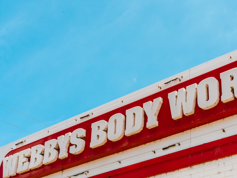 a sign that says webbby's body works on the side of a building