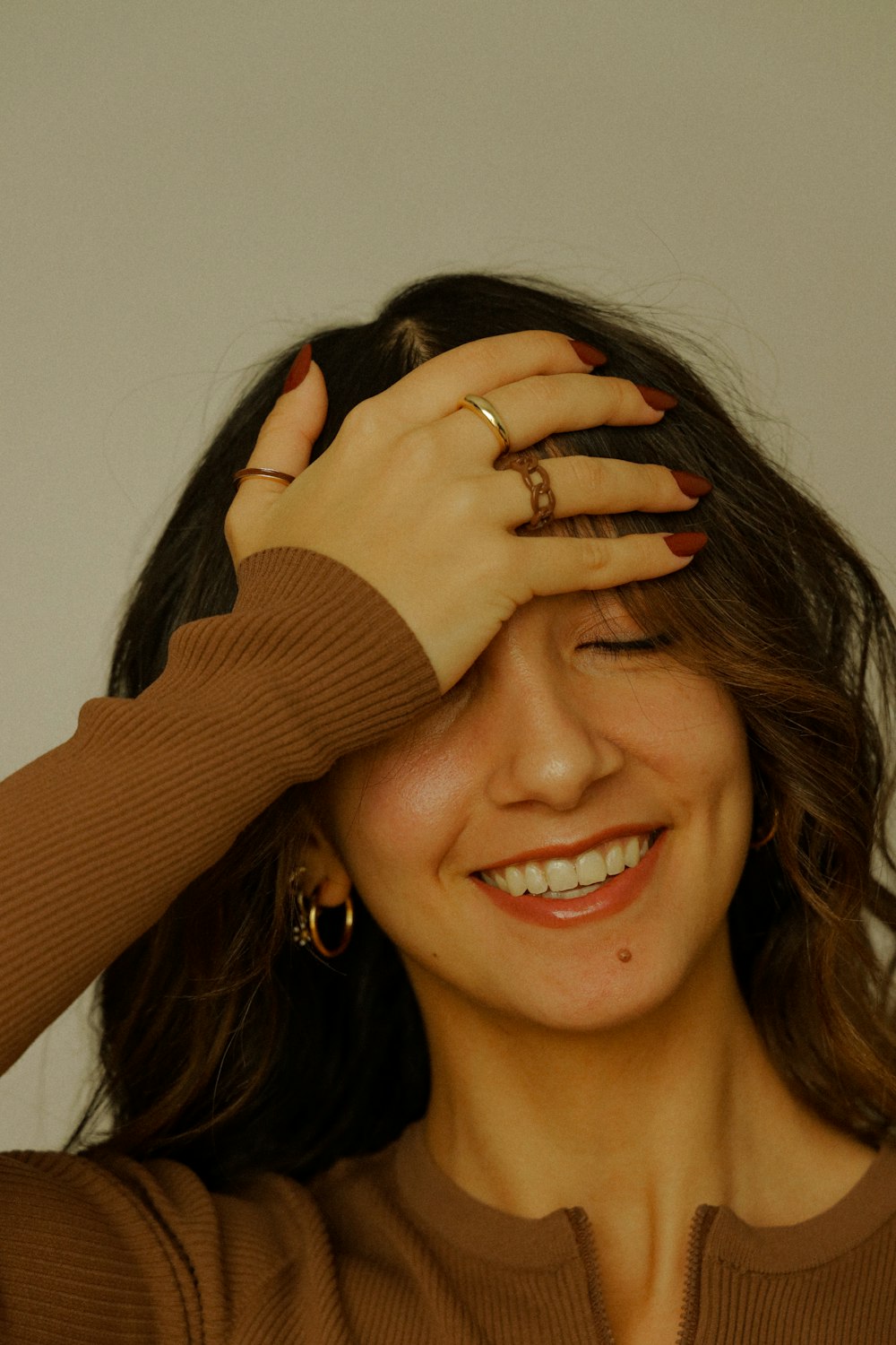 a woman smiling with her hands on her head
