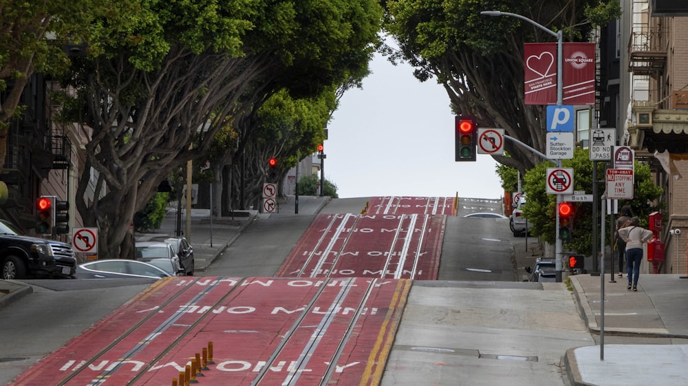 a street with a red light and a red sign on the side of the road