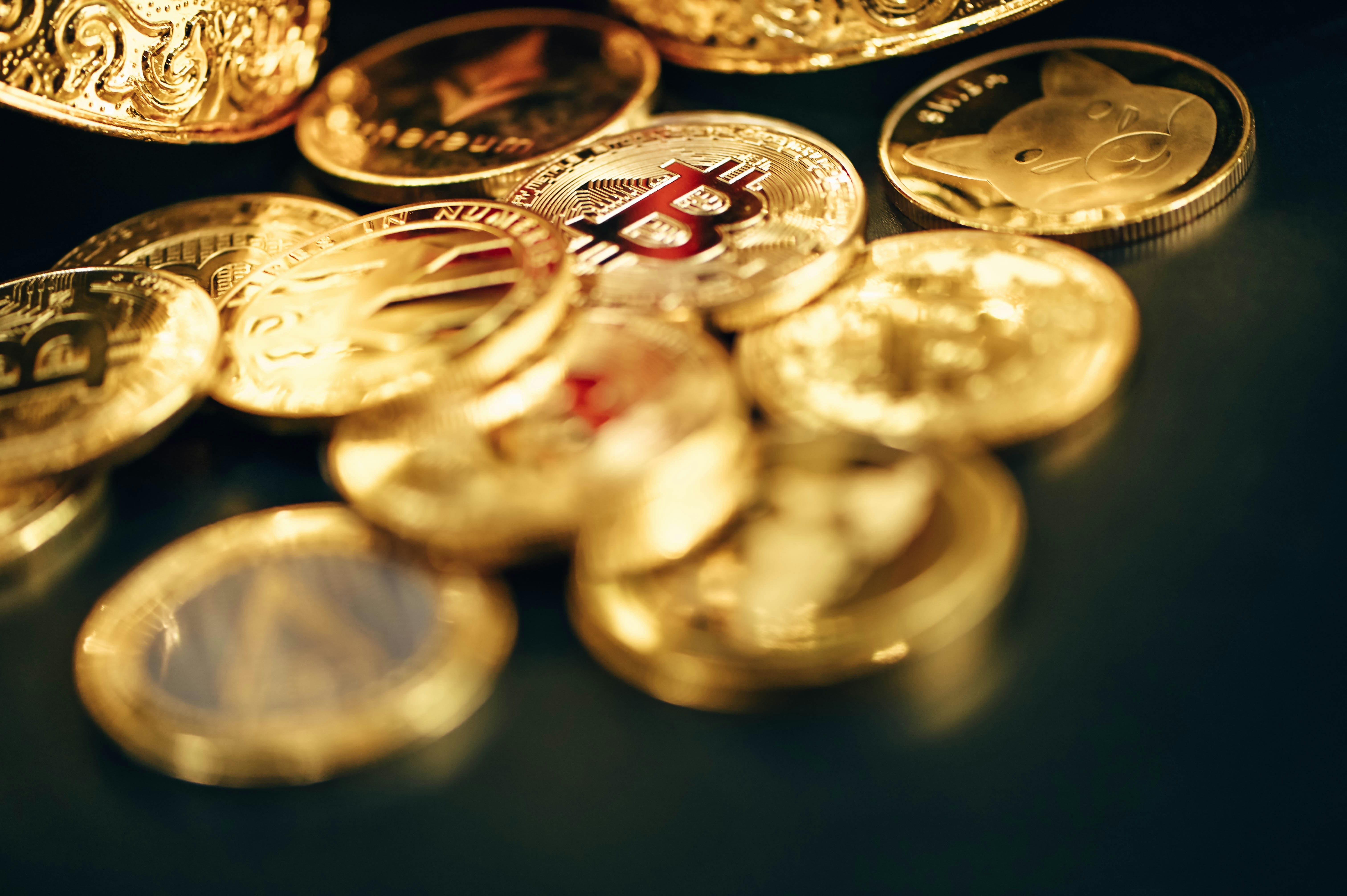 A group of gold cryptocurrencies on a dark surface