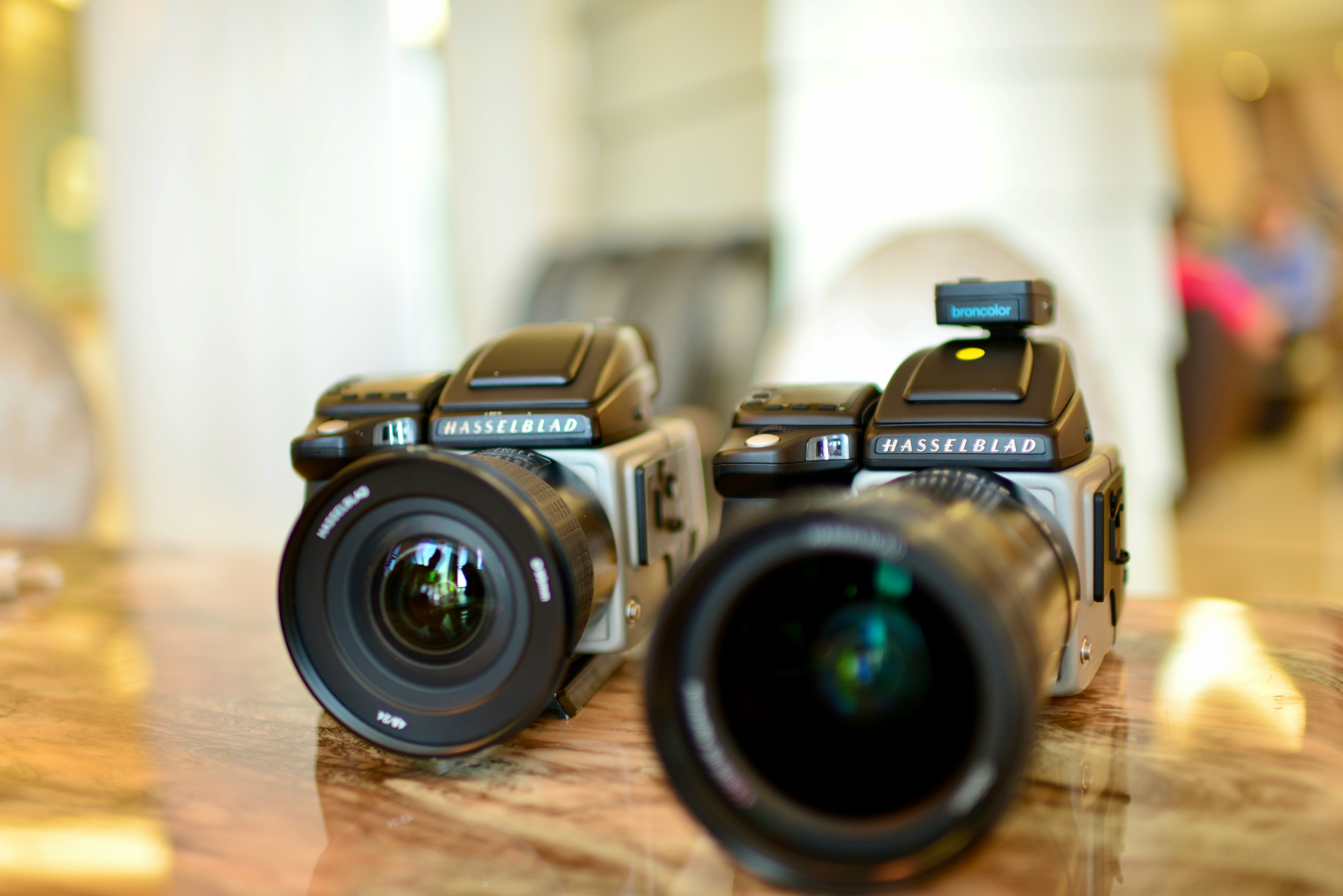 a couple of cameras sitting on top of a wooden table