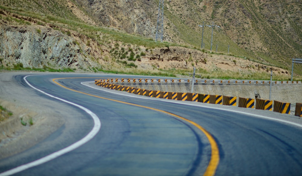 a curve in the road with a mountain in the background