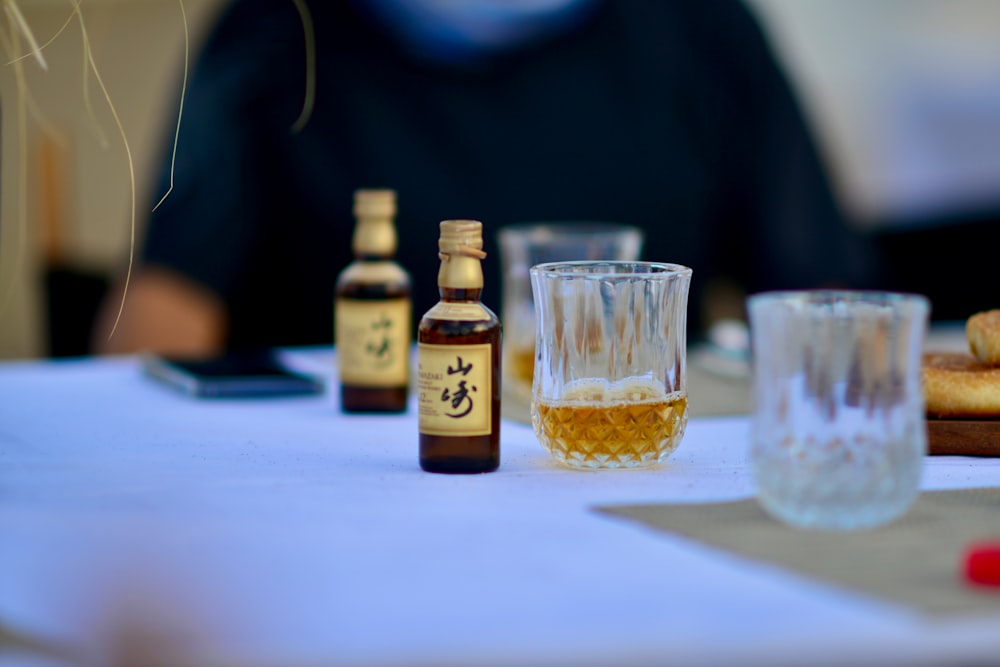 a table topped with glasses and bottles of alcohol