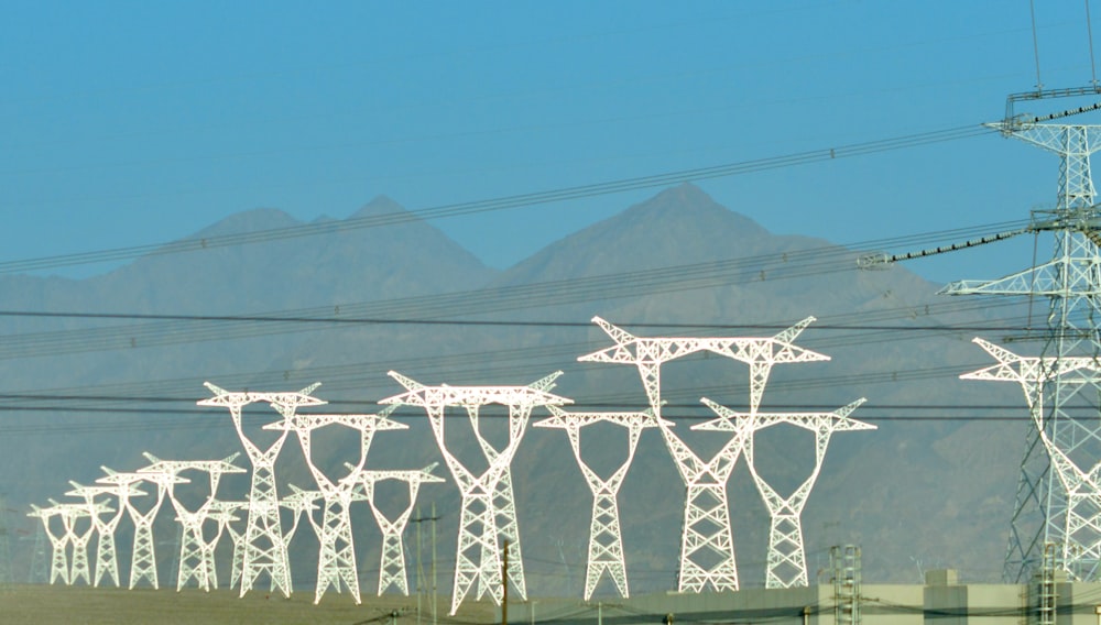 a row of power lines with mountains in the background