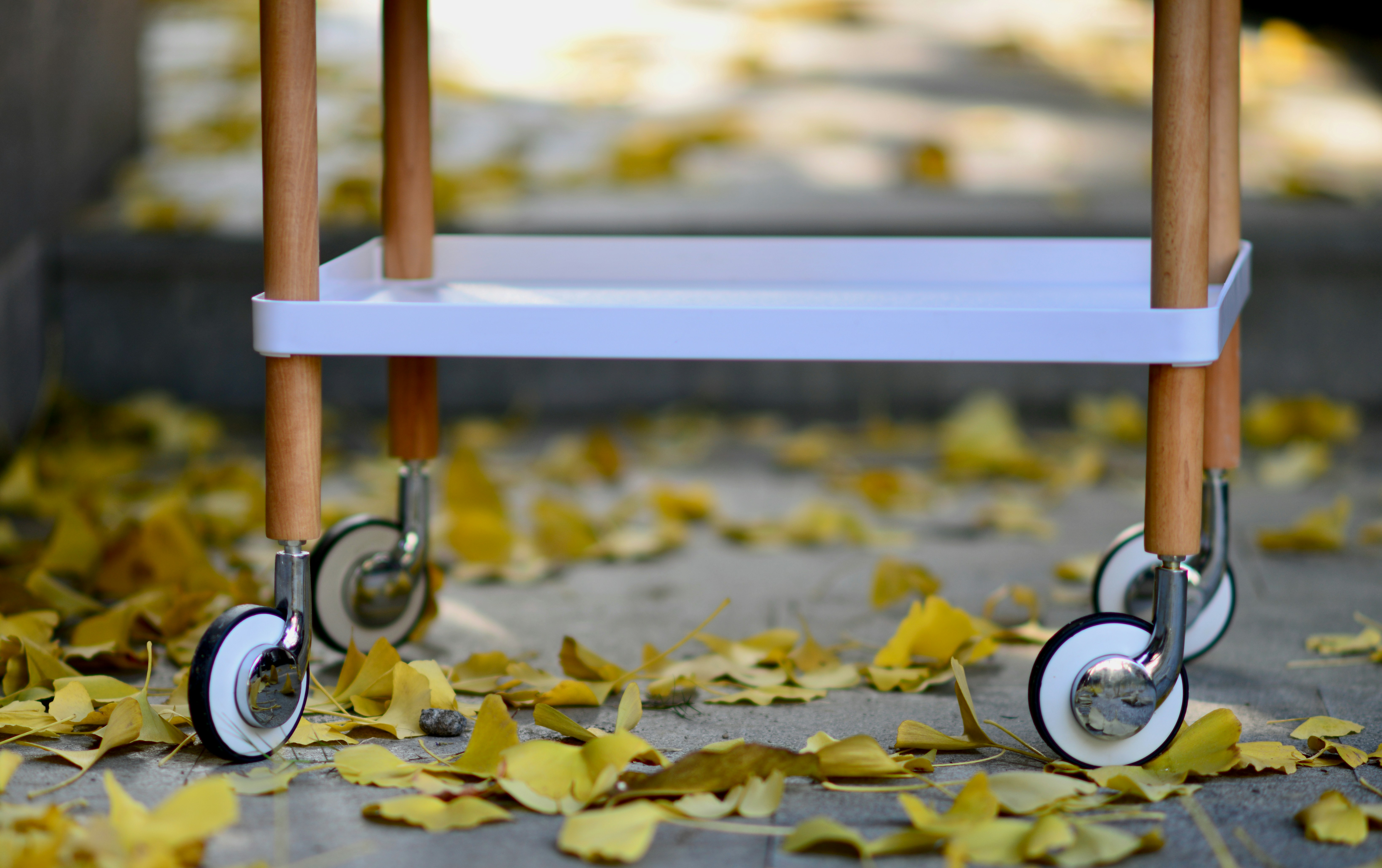 a small white cart with wheels on a sidewalk