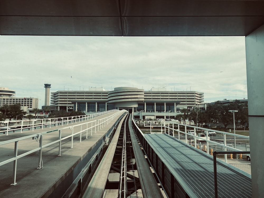 a train traveling past a large building on a cloudy day