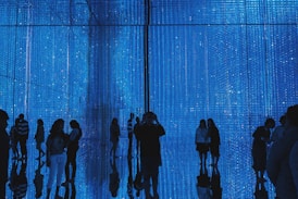 a group of people standing in front of a blue wall