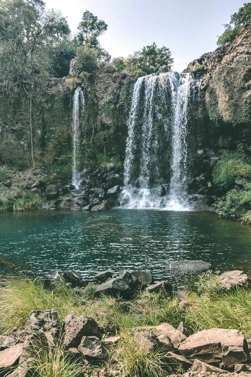 a large waterfall is in the middle of a body of water