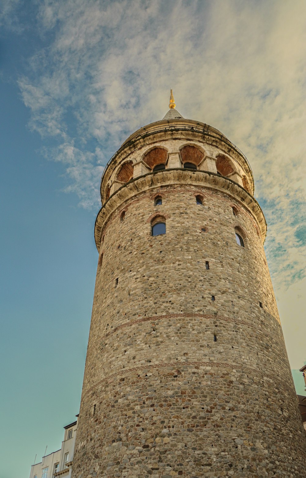 a very tall brick tower with a clock on it's side